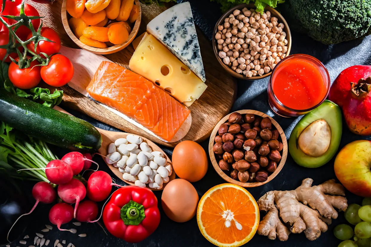 kobieta spaceruje uśmiechnięta po słonecznym parku z drzewami